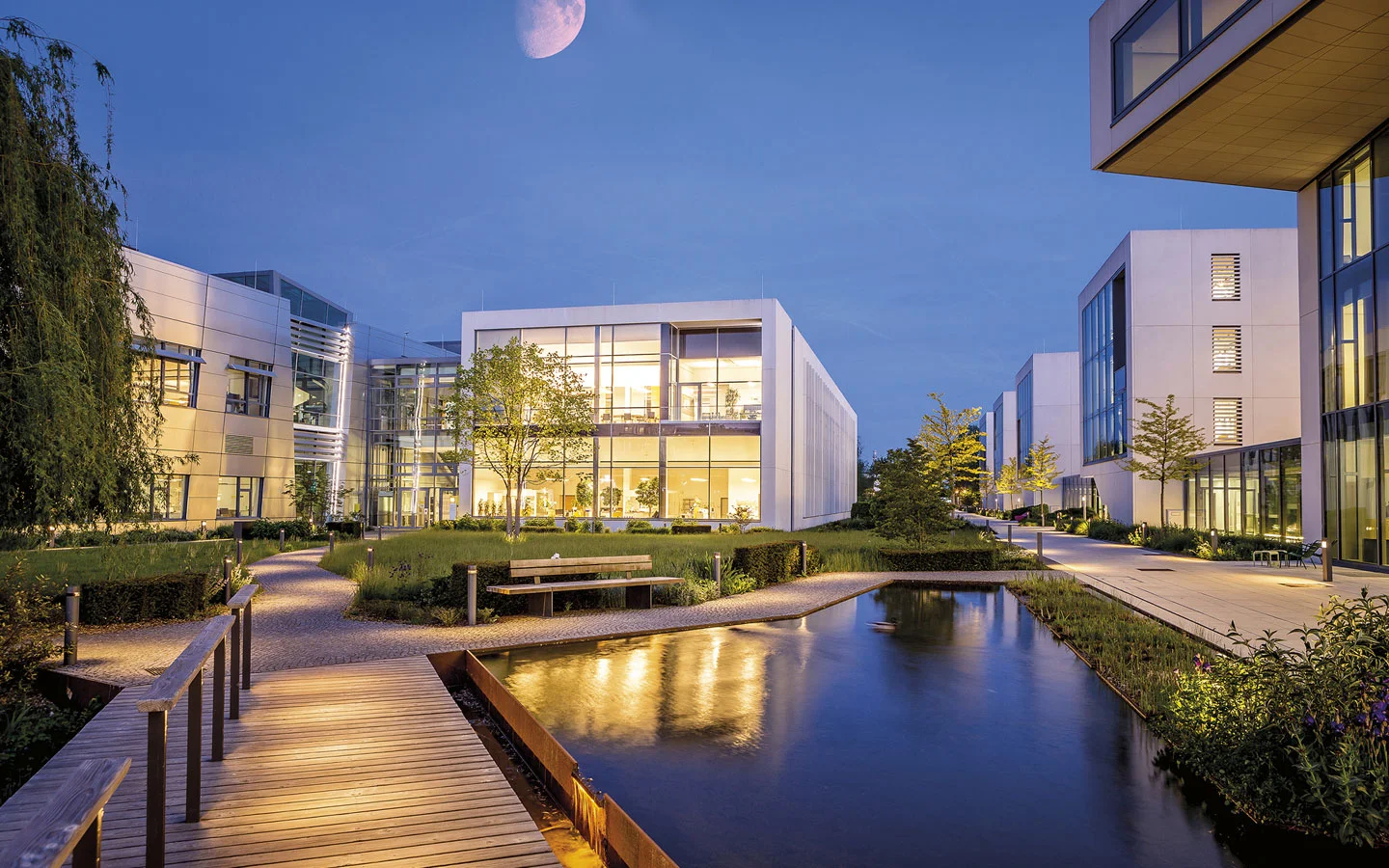 E-CHECK - Blick auf einige beleuchtete Gebäude am Abend · B+B Mess- und Sicherheitstechnik